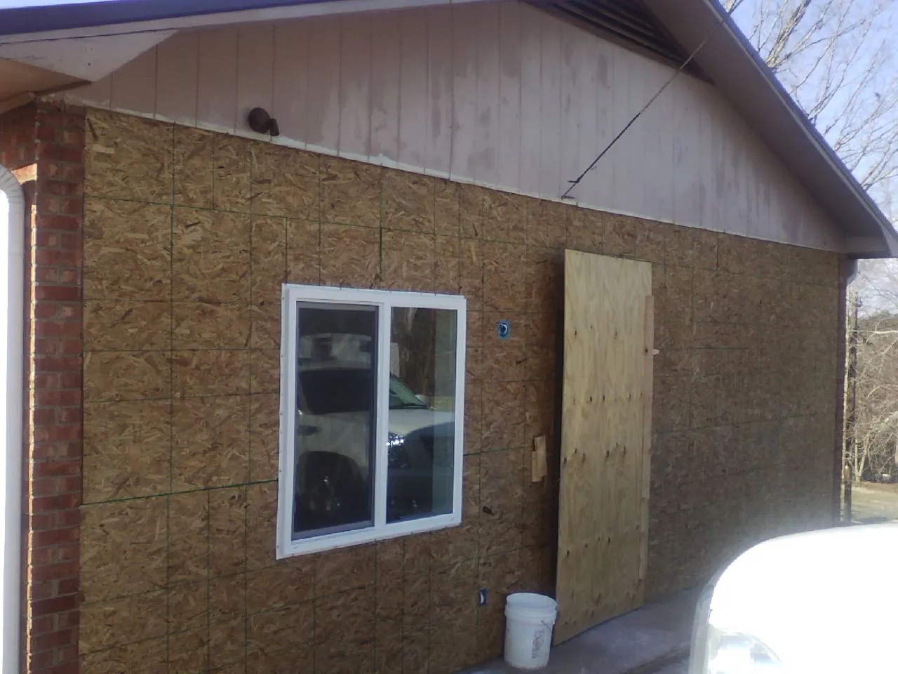 OSB sheathing on a garage addition wall before siding in Williston Park