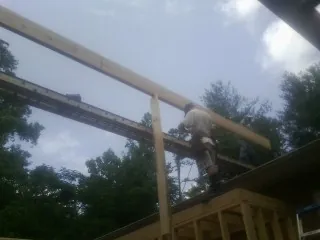 Carpenter setting a ridge beam over a new addition frame — Ice Dam Removal by Roofing Brothers in Williston Park