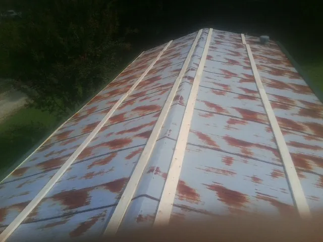 Rusted metal roof panels with new wood purlins before replacement — Storm Damage Roof Repair in Williston Park by Roofing Brothers