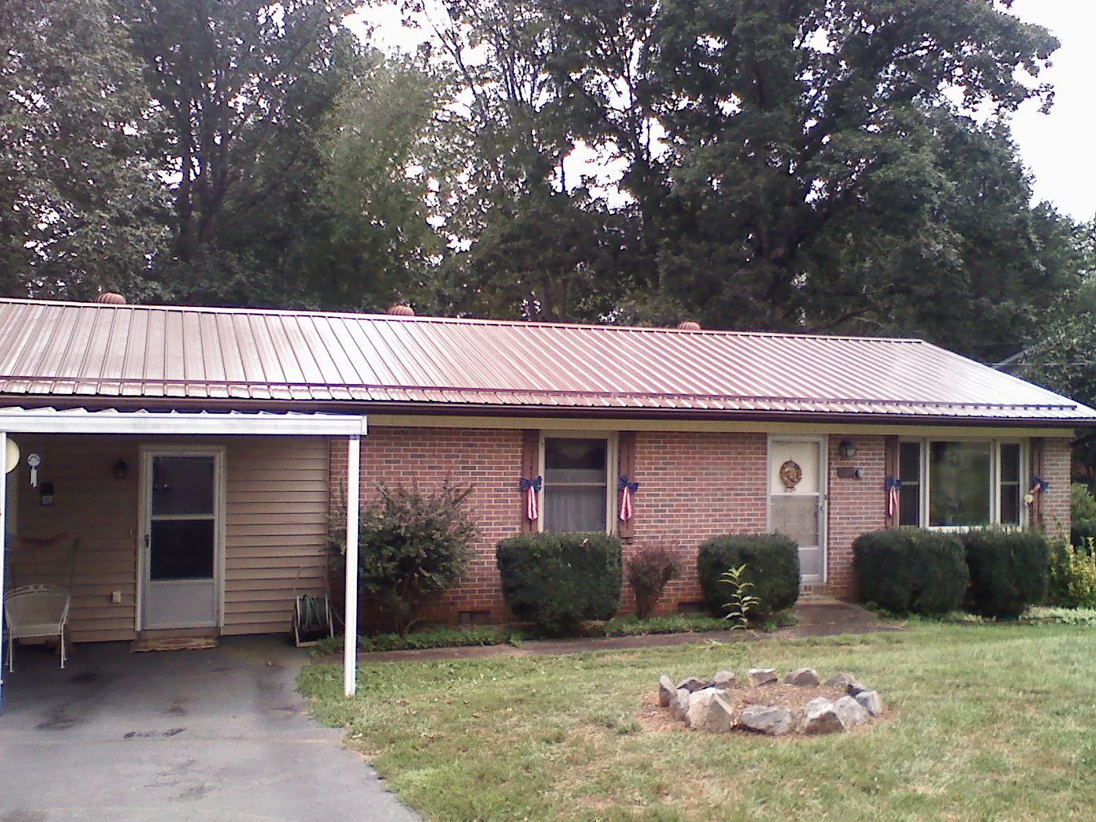 Bronze metal roof and carport on a brick ranch home — Roof Repair work by our crew in Williston Park